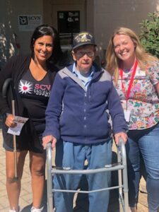 Picture of 102 Year old Frank with a walker and two volunteers from SCVN
